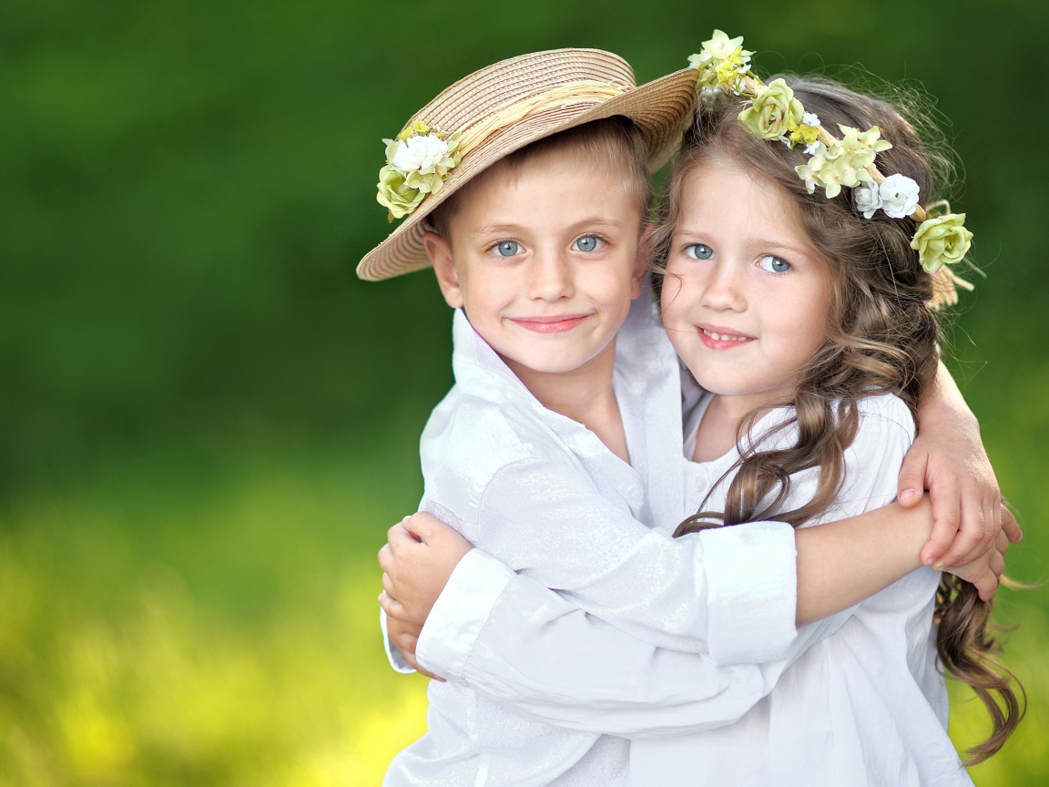 Маленькие мальчик и девочка обнимают друг друга