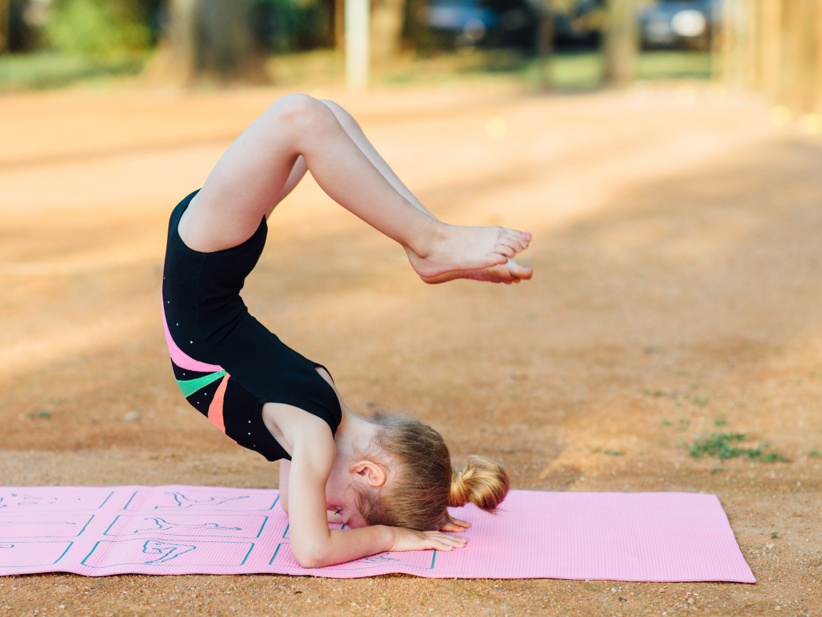 Маленькая девочка занимается гимнастикой