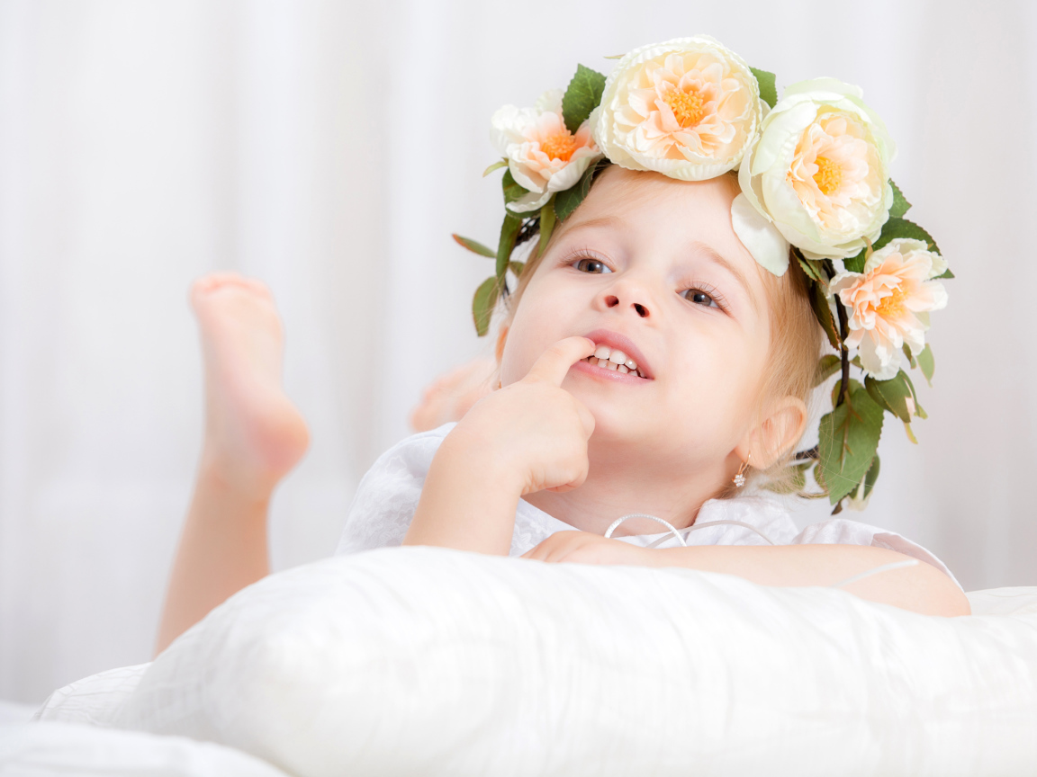 Маленькая девочка с красивым венком из цветов на голове