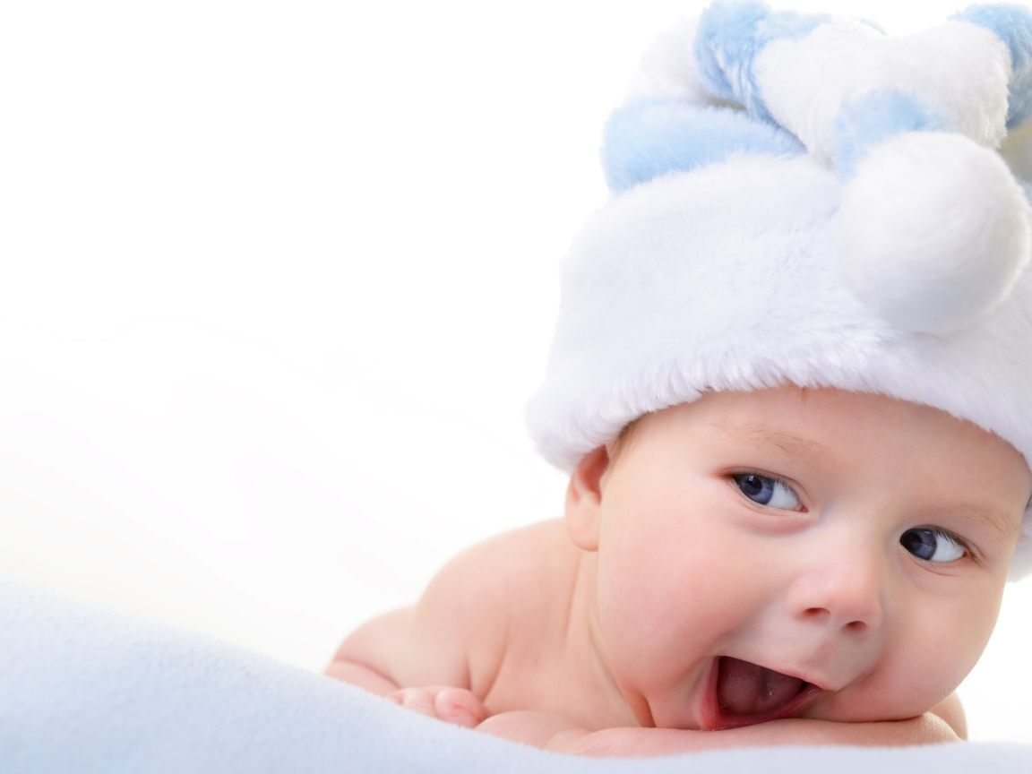 Улыбающийся грудной ребенок в голубой новогодней шапке