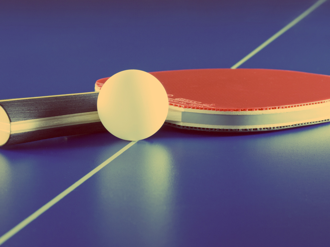 Ракетка для настольного тенниса и мяч на фиолетовом столе 