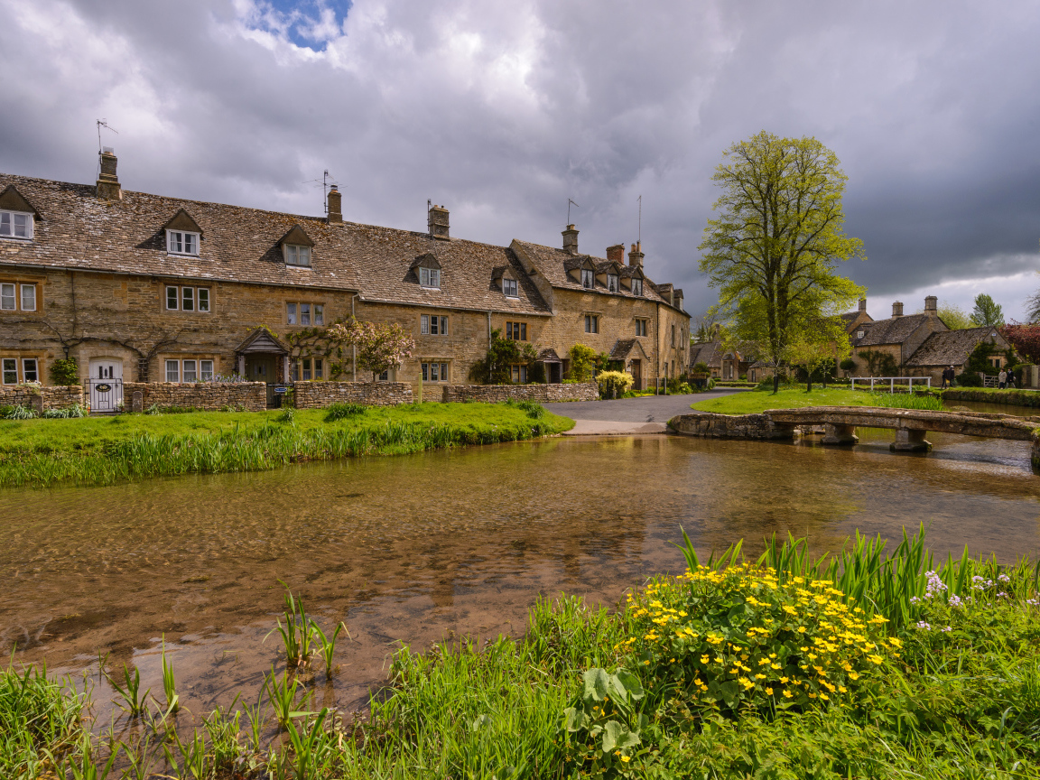 Дом у озера с покрытыми зеленой травой берегами, Англия