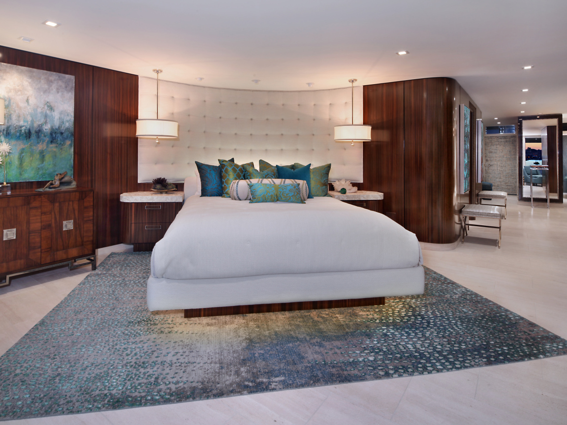 Большая кровать с белым покрывалом в спальне в коричневых тонах