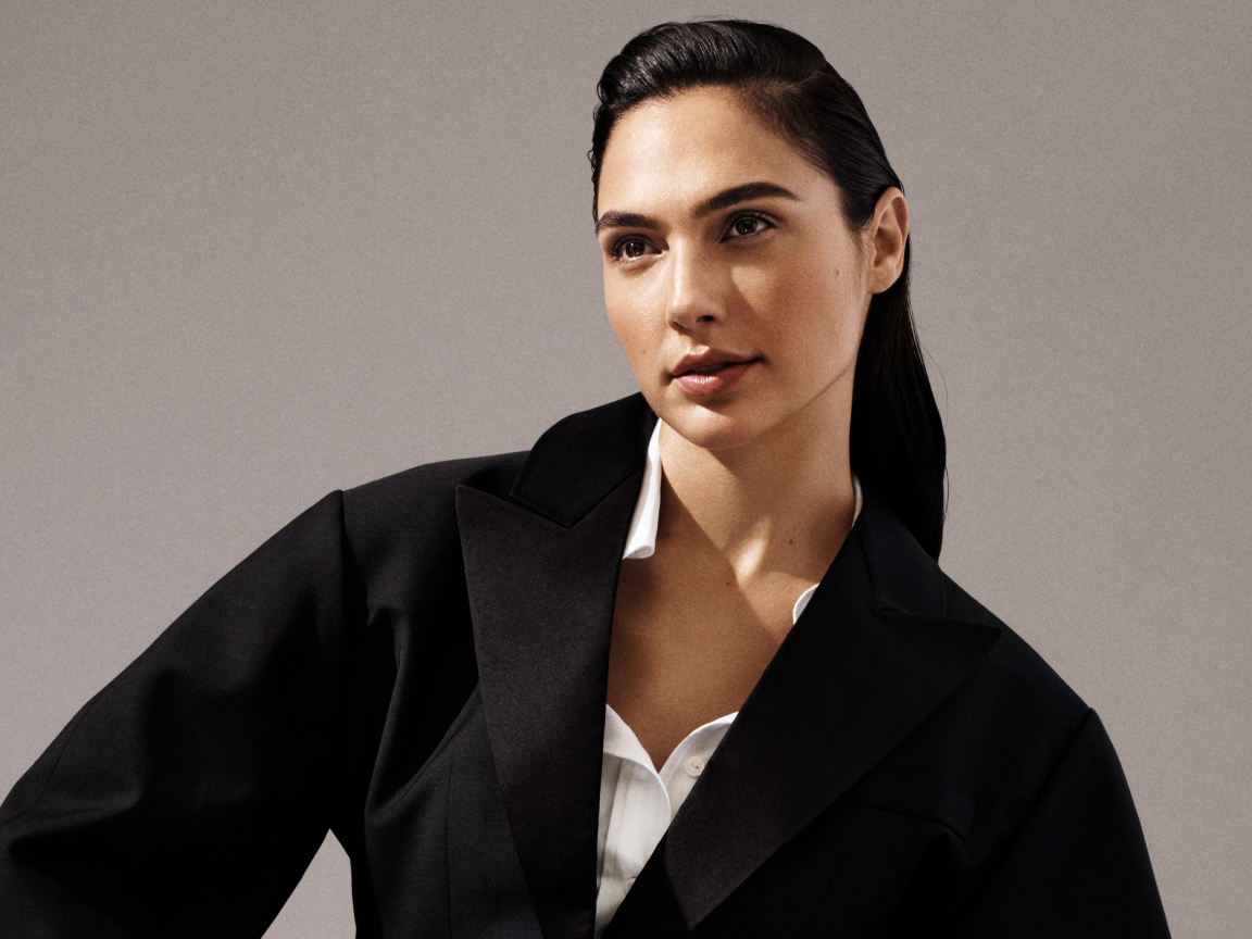 Актриса Галь Гадот в черном пальто на сером фоне