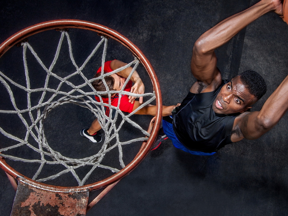 Баскетболист забрасывает мяч в кольцо 