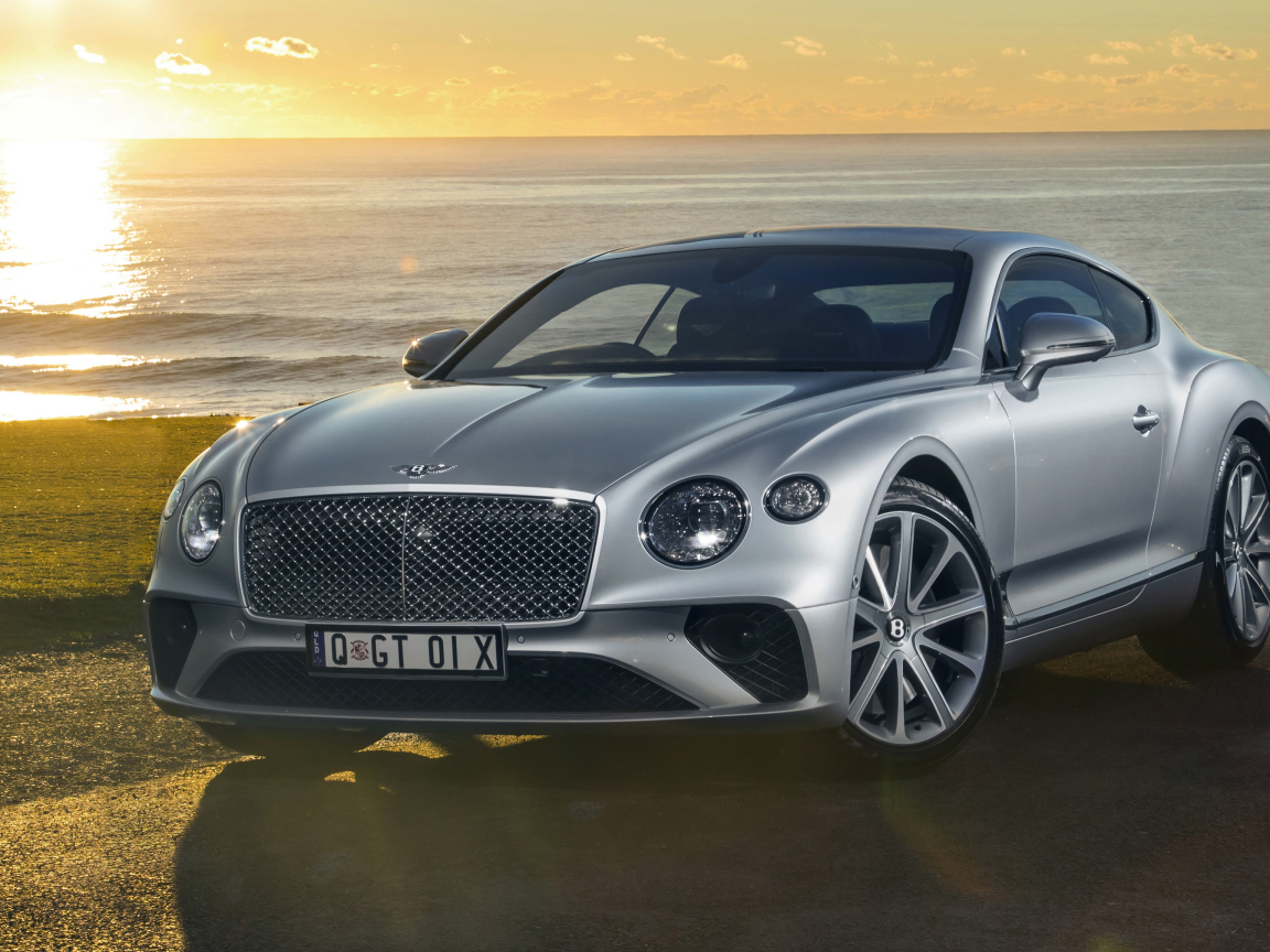 Серебристый Bentley Continental GT 2018 года на фоне моря