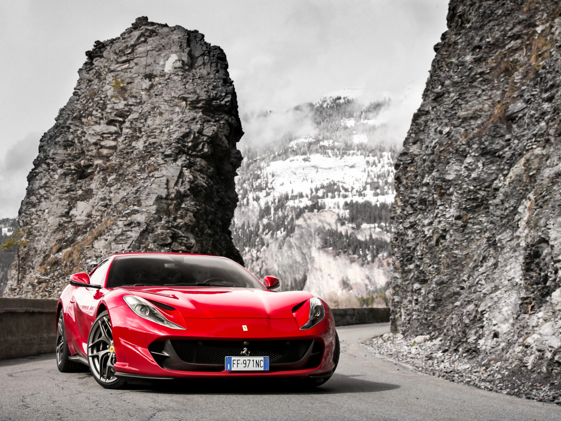 Красный спортивный автомобиль Ferrari Portofino 2018 года на фоне гор