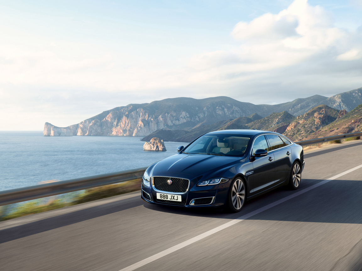 Черный автомобиль Jaguar XJ50, 2018 года на трассе