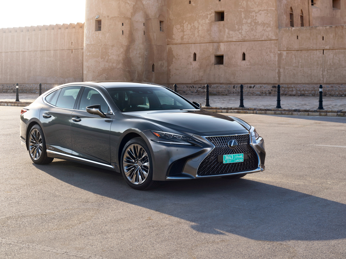 Стильный автомобиль Lexus LS 500h AWD, 2018 на фоне крепости