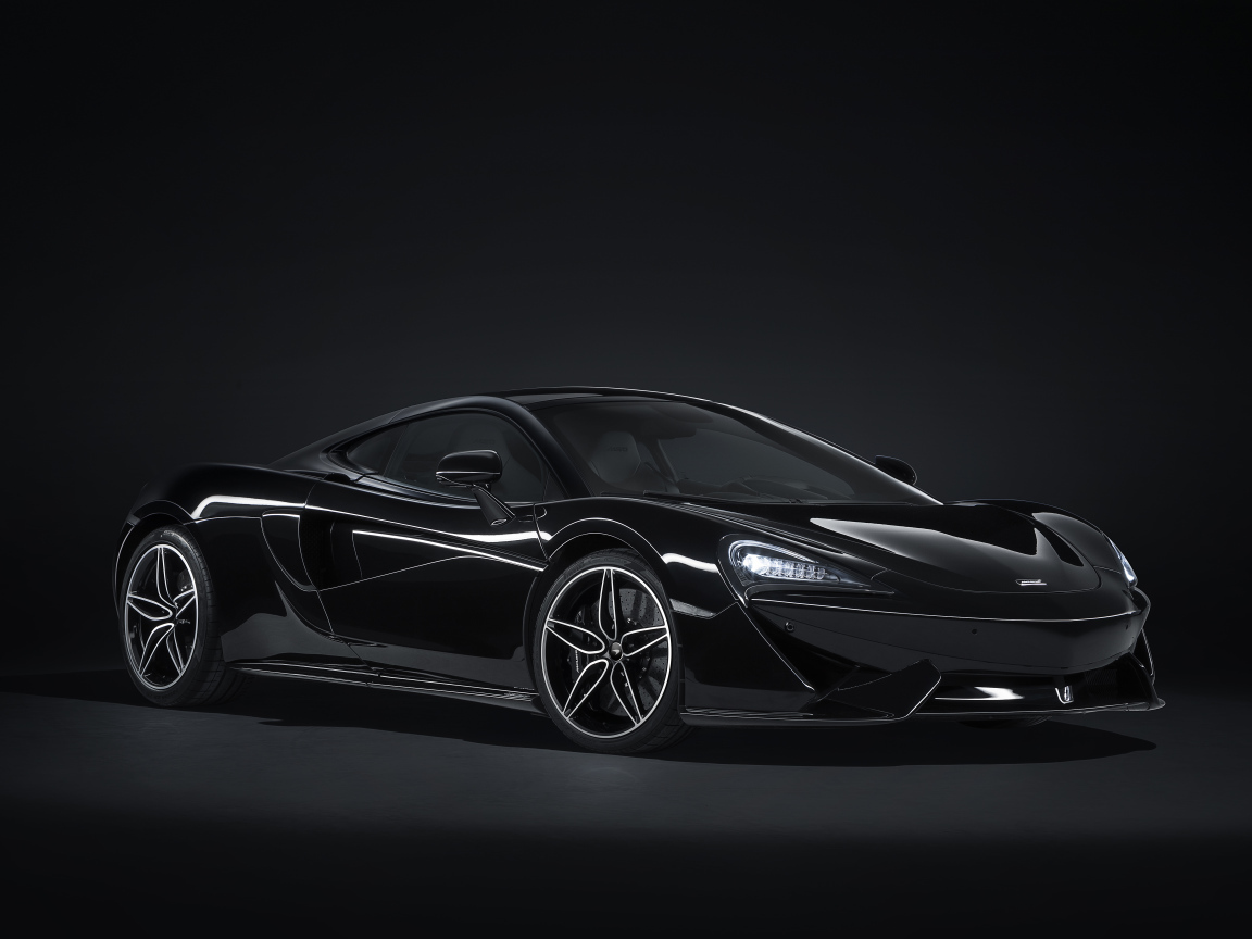 Черный автомобиль McLaren 570GT на сером фоне