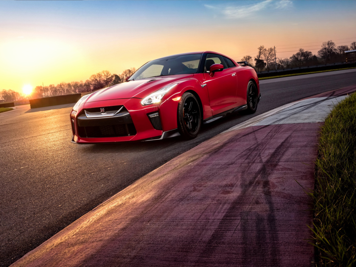Красный автомобиль Nissan GT-R 2018 года на трассе на закате