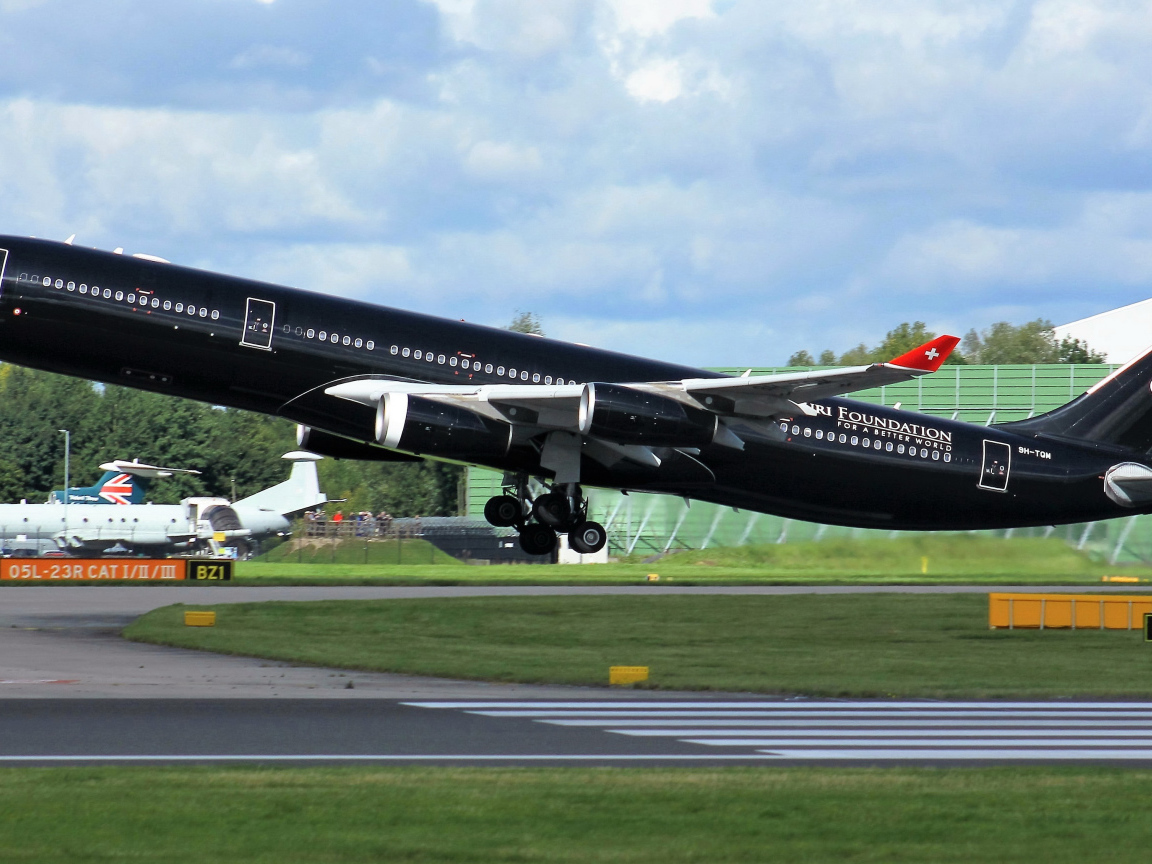 Черный пассажирский самолет Airbus A340-313 на взлете