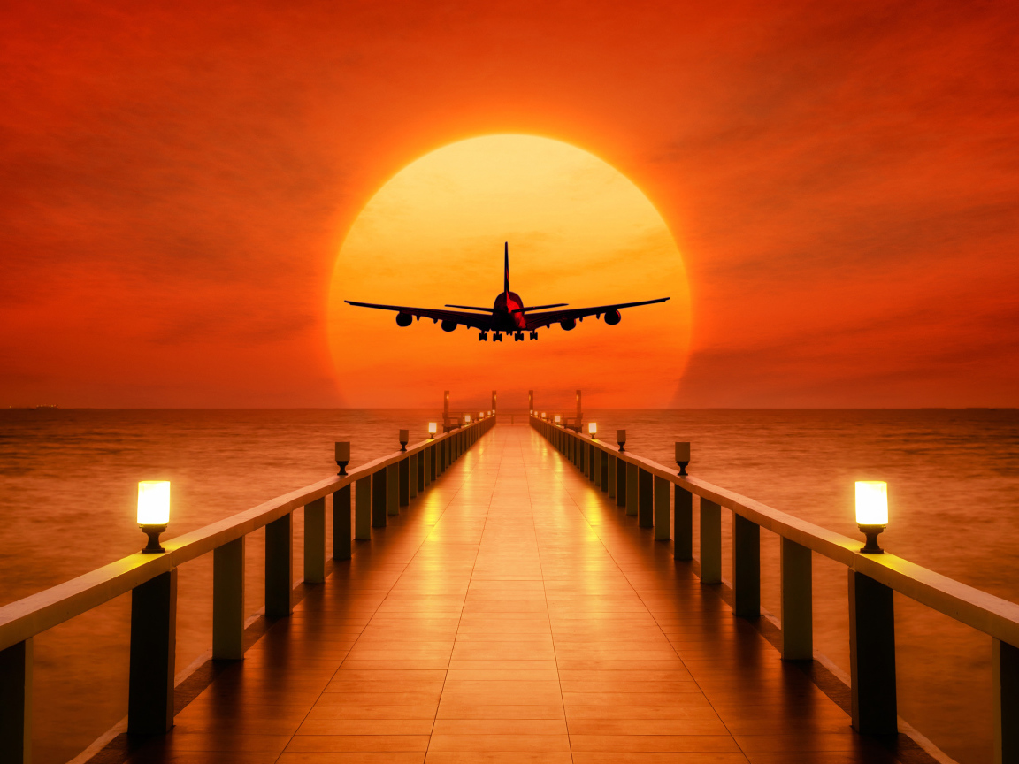 Самолет идет на посадку на закате солнца над океаном