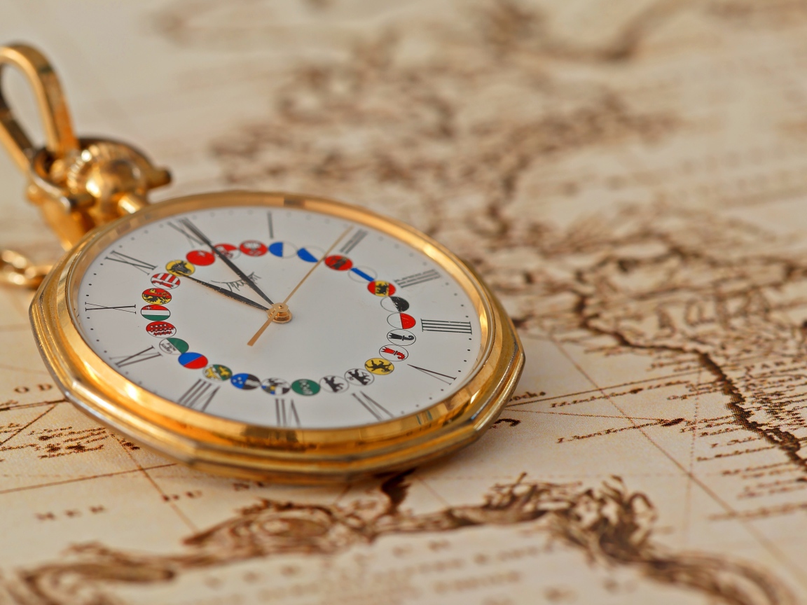 Карманные часы в золотой оправе лежат на карте