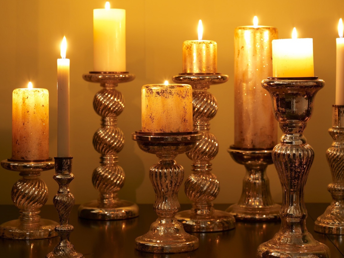 Старинные подсвечники с зажженными свечами на столе 