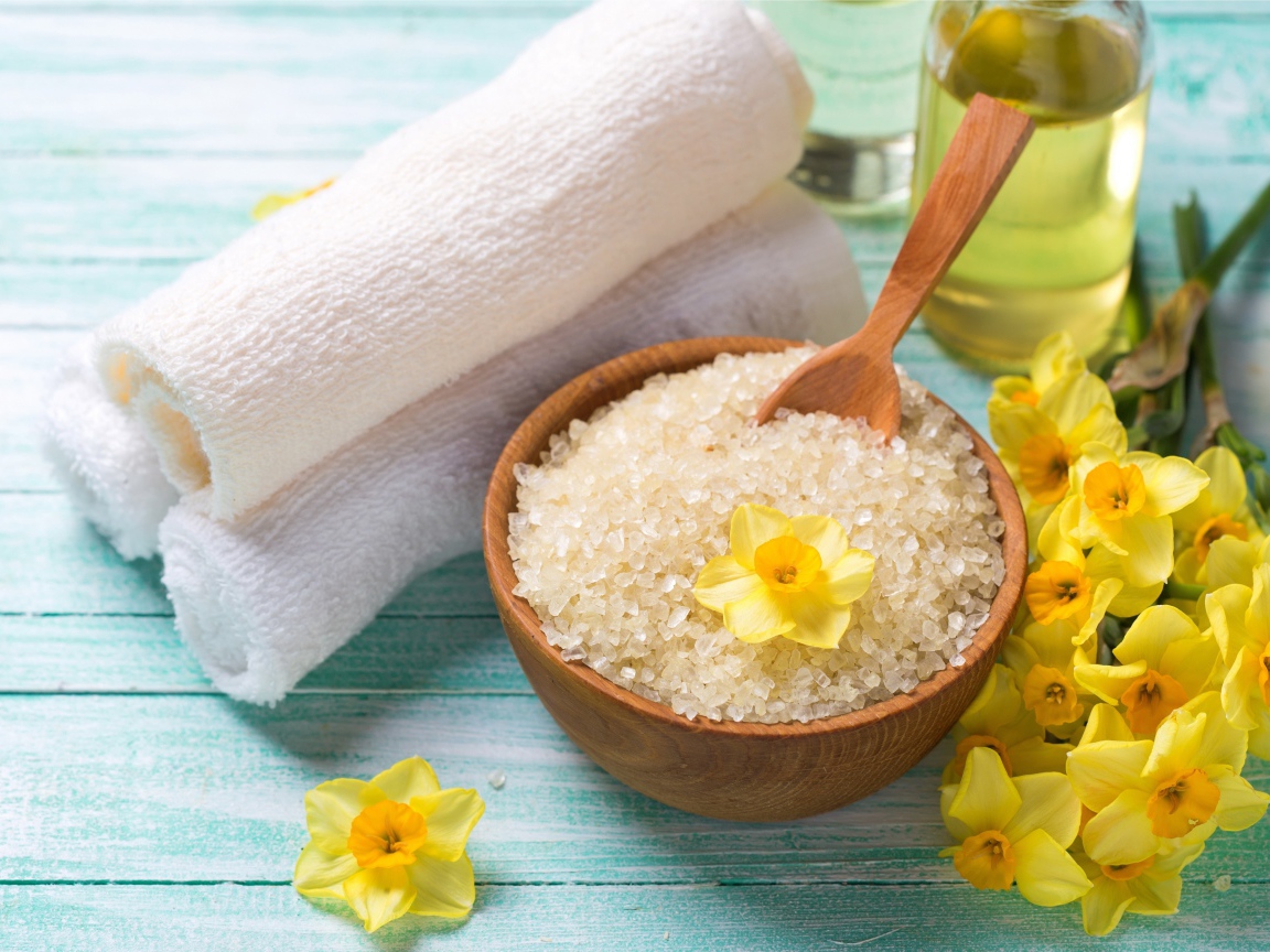 Соль с цветами нарцисса и полотенцем на столе