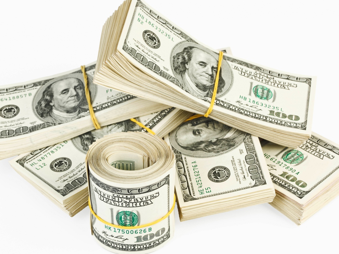 Пачки банкнот по сто долларов на белом фоне