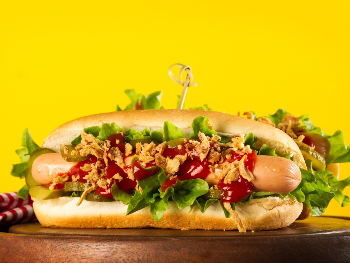 Аппетитные хотдоги на желтом фоне крупным планом