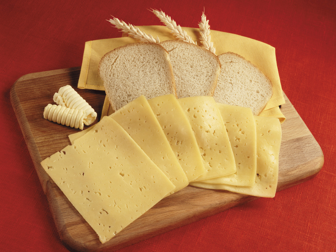 Хлеб с кусками сыра на разделочной доске