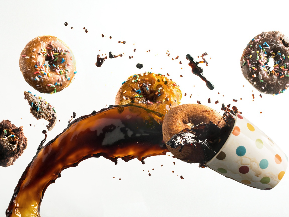 Пончики с чашкой кофе на белом фоне