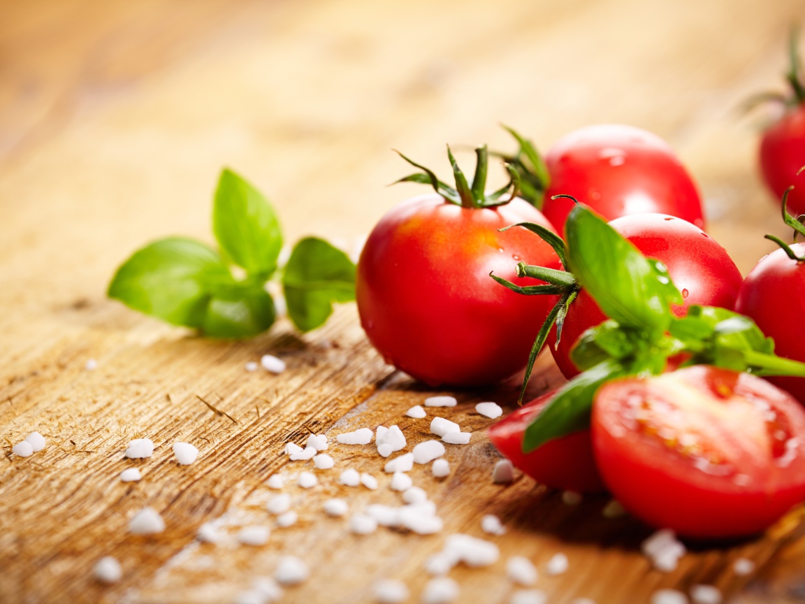 Красные помидоры с солью на столе