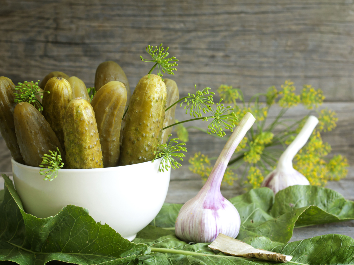 Соленые огурцы на столе с чесноком и укропом