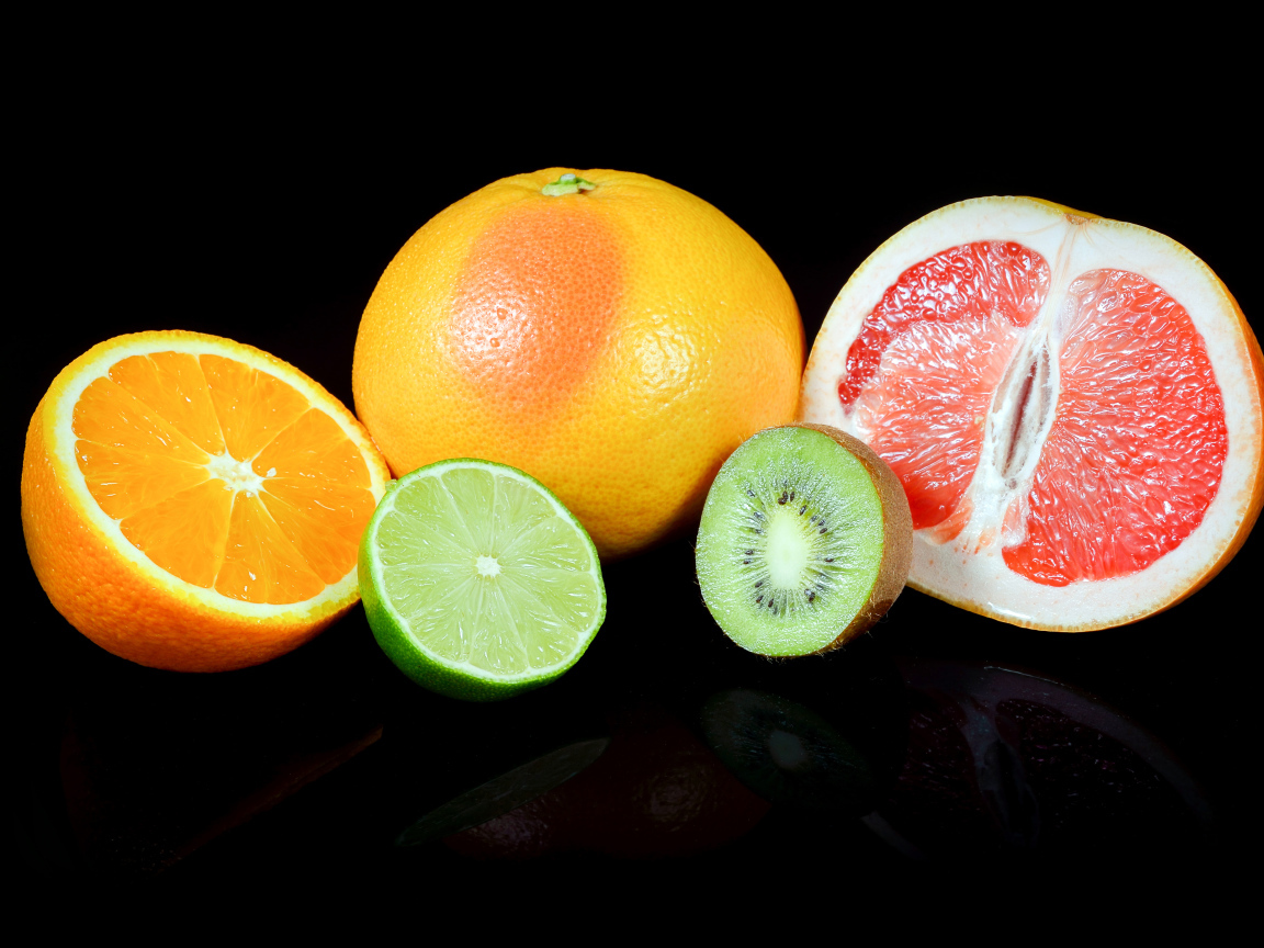 Апельсины, грейпфруты,  лайм и киви на черном фоне