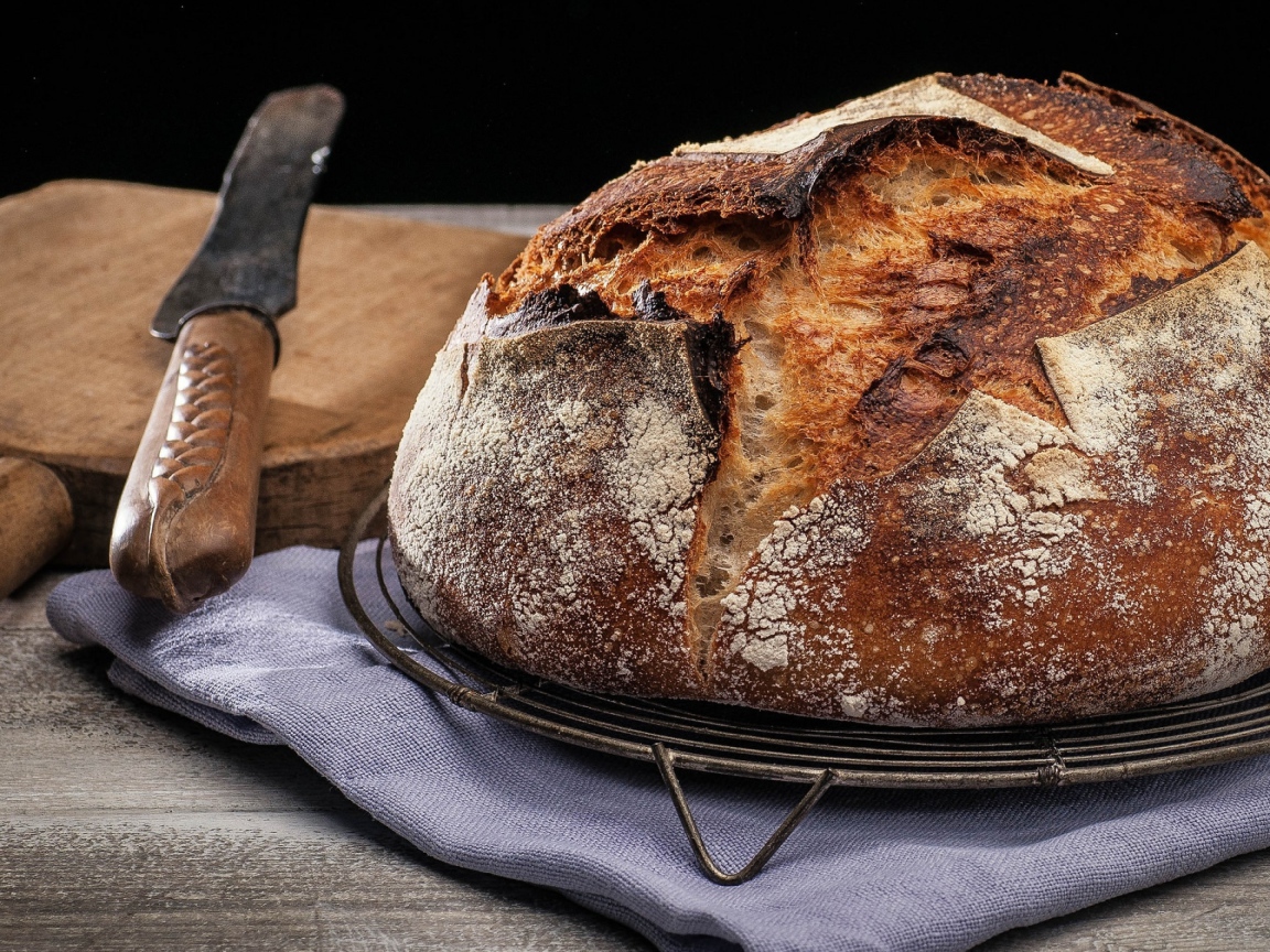 Зажареный круглый хлеб на столе с ножом