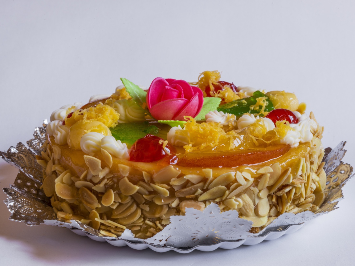 Красивый торт с кремом и ягодами украшен розовым цветком