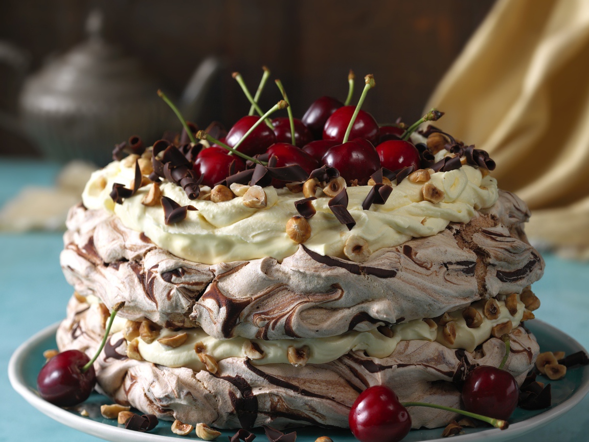 Красивый кремовый торт с шоколадом и ягодами черешни и орехами