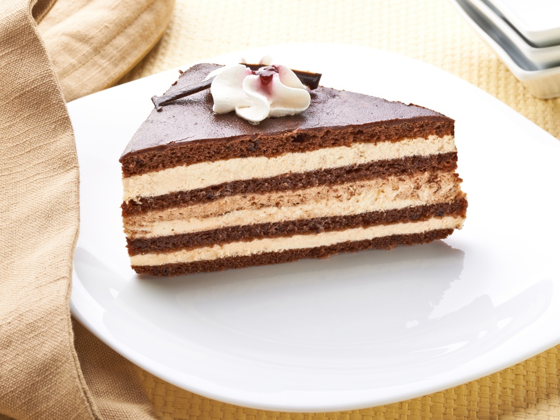 Большой кусок торта с кремом украшен цветком