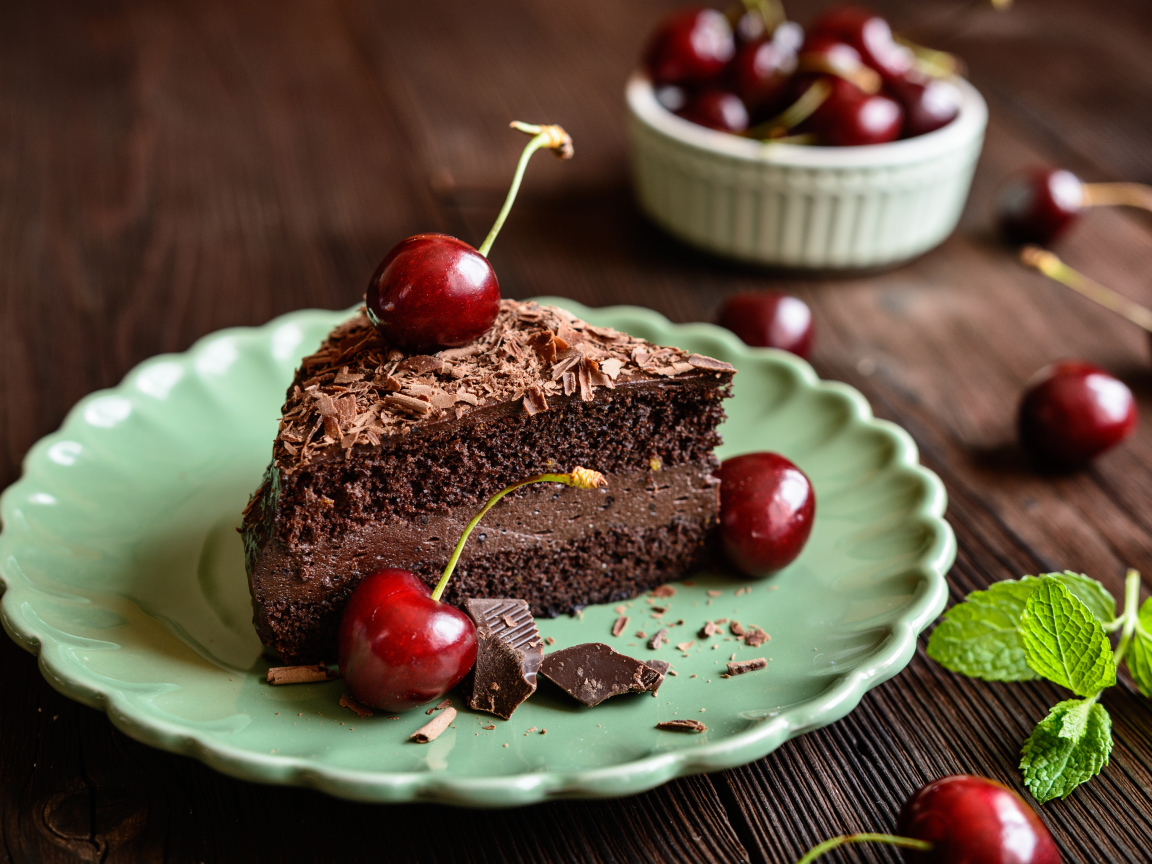 Кусок пирожного с черешнями на тарелке