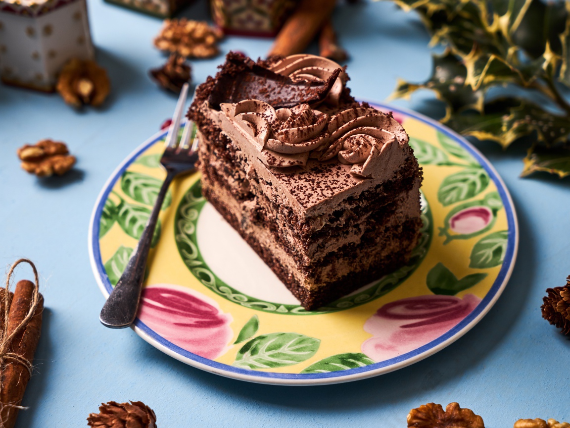 Кусок торта с кремом и шоколадом на тарелке 