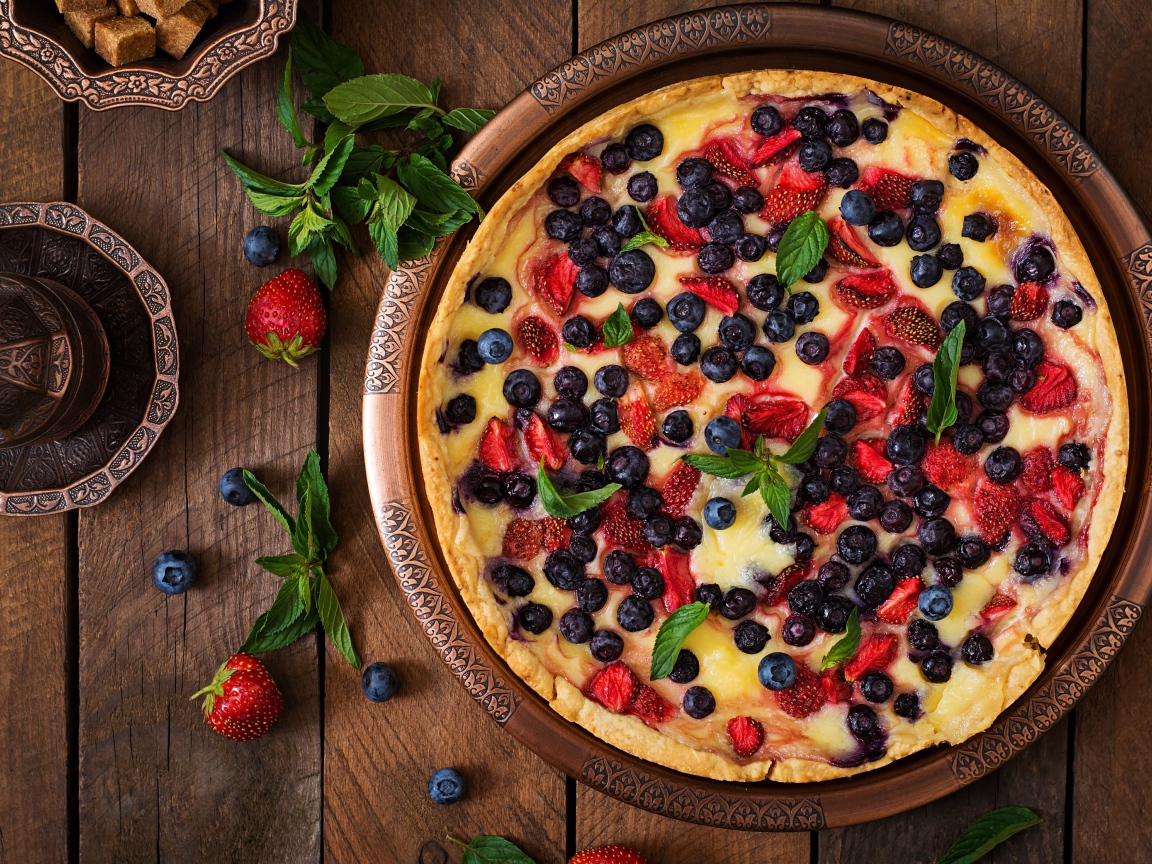 Аппетитный пирог с ягодами на деревянном столе