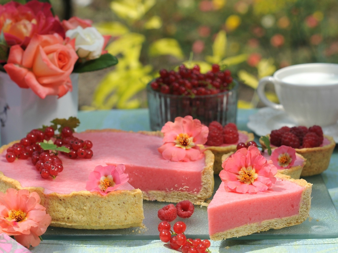 Аппетитный пирог с ягодами малины и красной смородины на столе с цветами