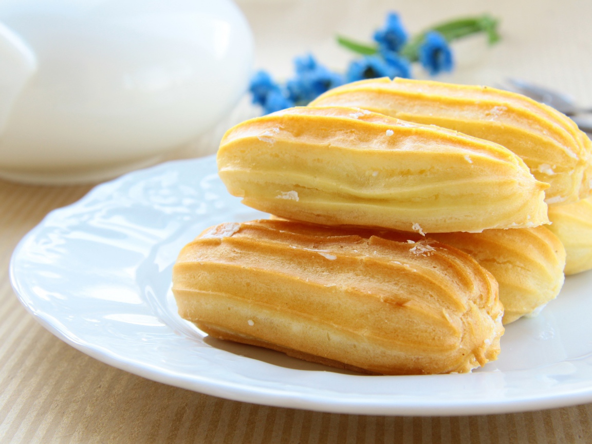 Заварные пирожные на большой белой тарелке 