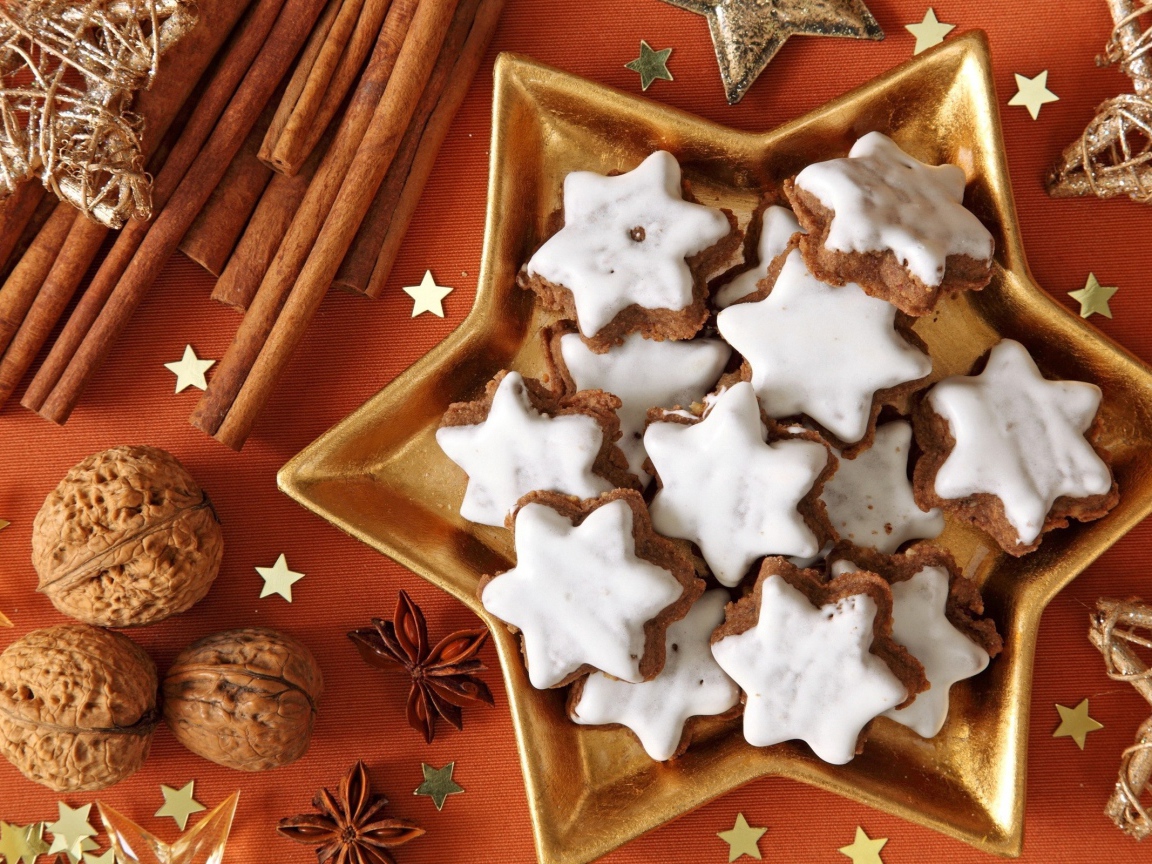 Печенье с глазурью на столе с орехами, корицей и бадьяном