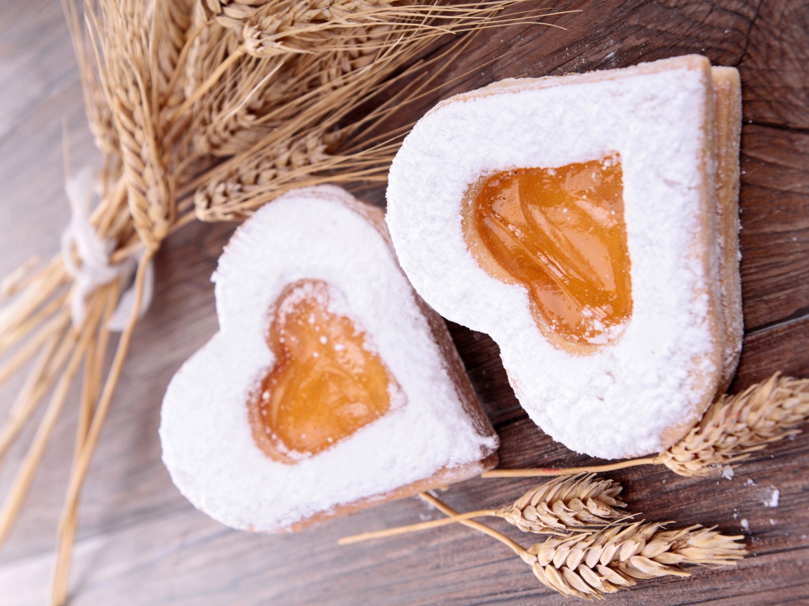 Печенье в форме сердца на столе с колосьями пшеницы