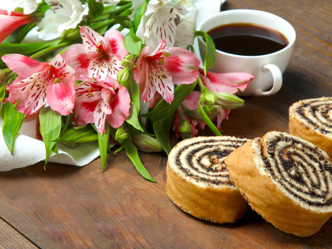 Рулет с маком на столе с цветами альстрёмерия и чашкой кофе