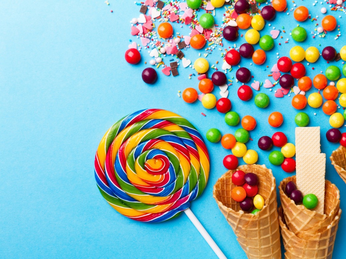 Сладкие конфеты и вафельные рожки на голубом фоне