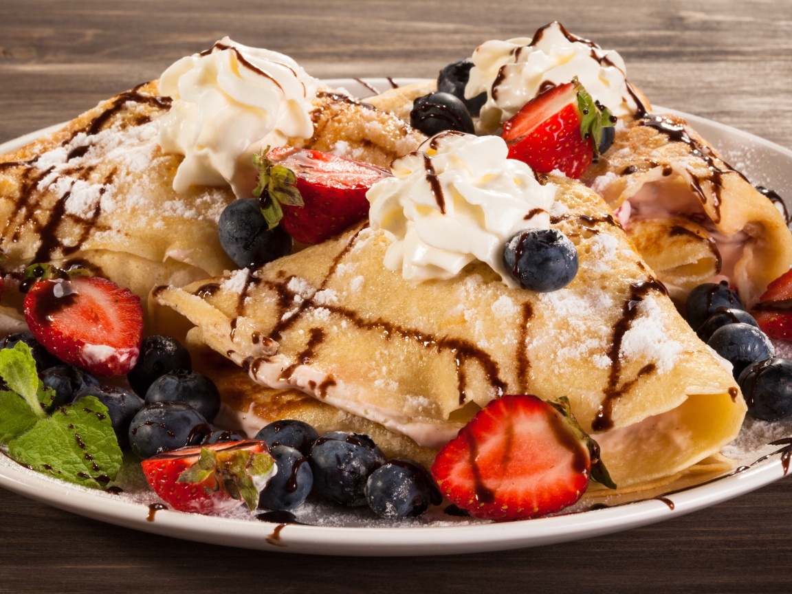 Сладкие блины с кремом, ягодами клубники и черники