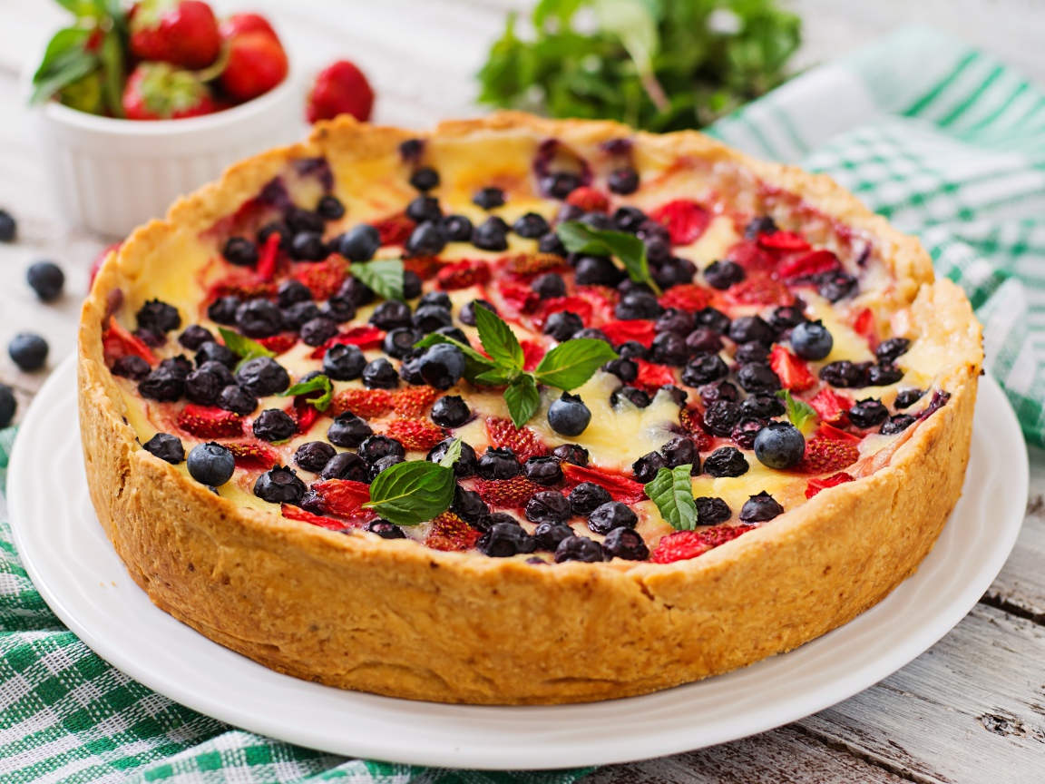 Сладкий пирог с черникой и клубникой на белом блюде