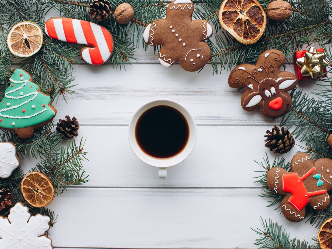 Чашка кофе на деревянном столе с имбирным печенье, еловыми ветками и декором