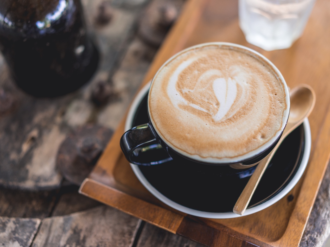 Большая чашка кофе с пеной на столе