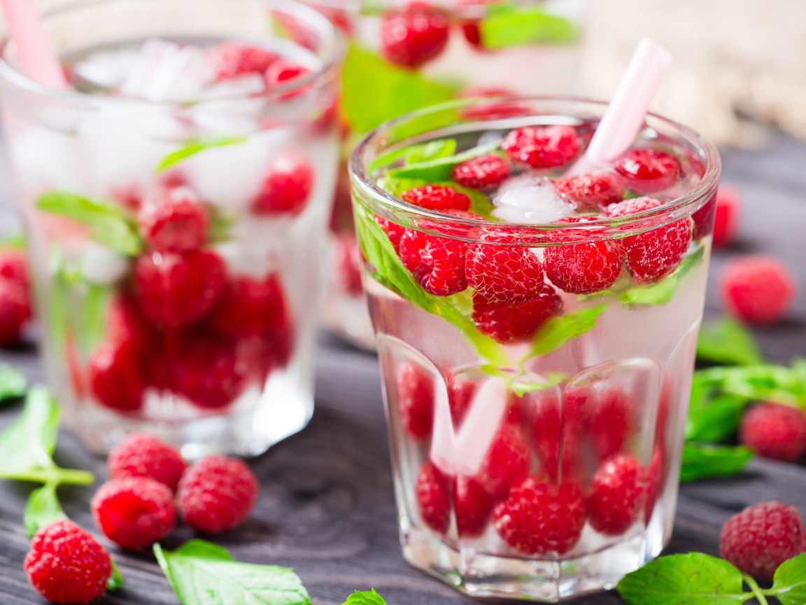 Напиток в стакане с малиной и кубиками льда