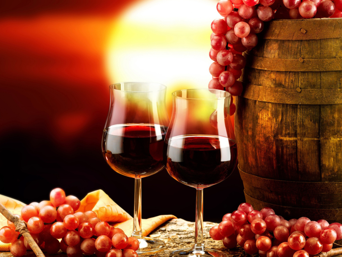 Два бокала вина на столе с бочкой и гроздьями винограда 