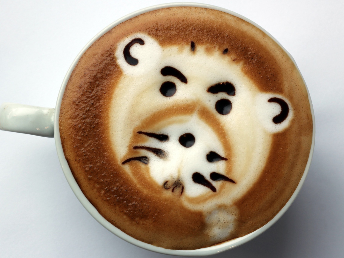 Белая чашка кофе с забавным рисунком на пене