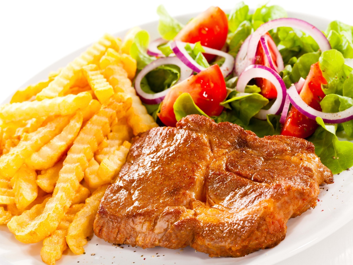 Аппетитная отбивная на тарелке с картофелем фри и салатом