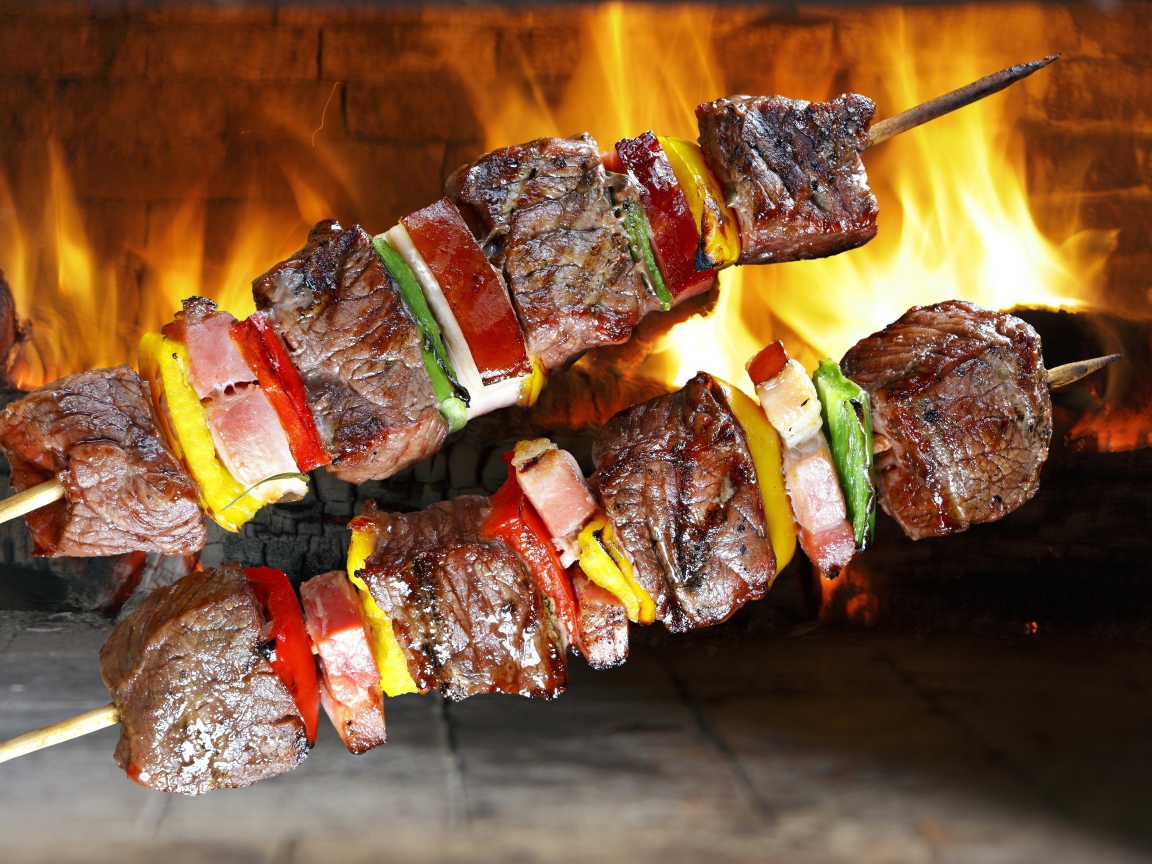 Аппетитный шашлык с овощами на фоне огня