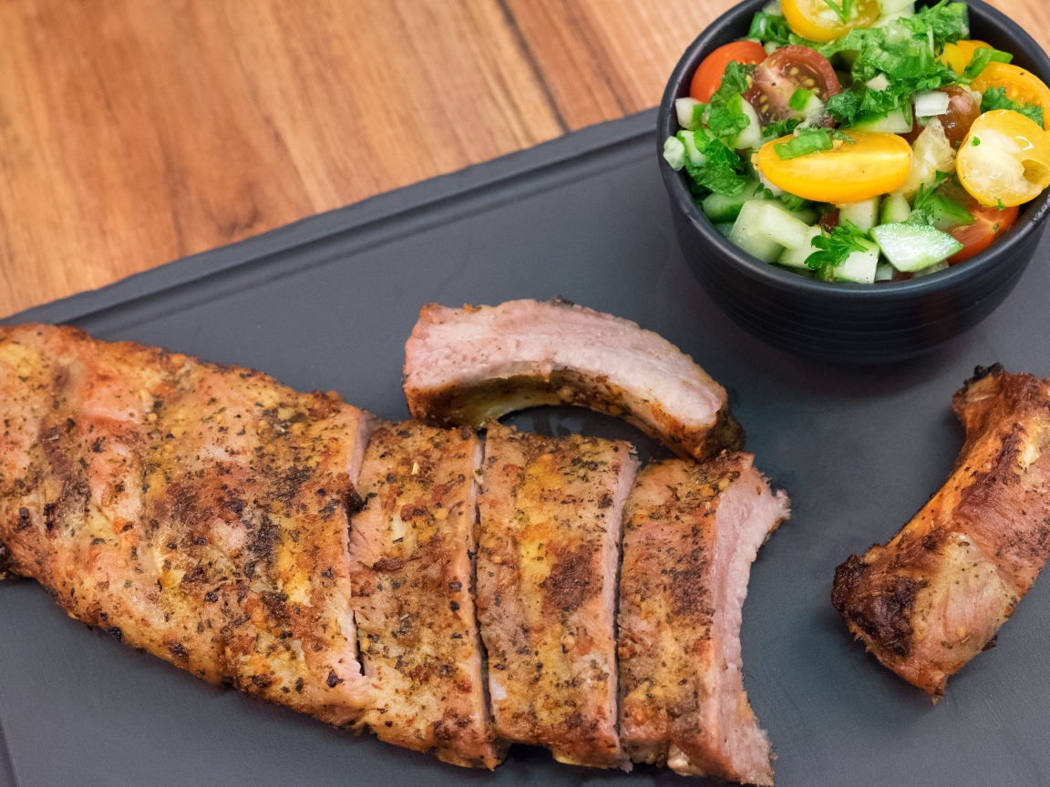 Жареные ребрышки с салатом на столе